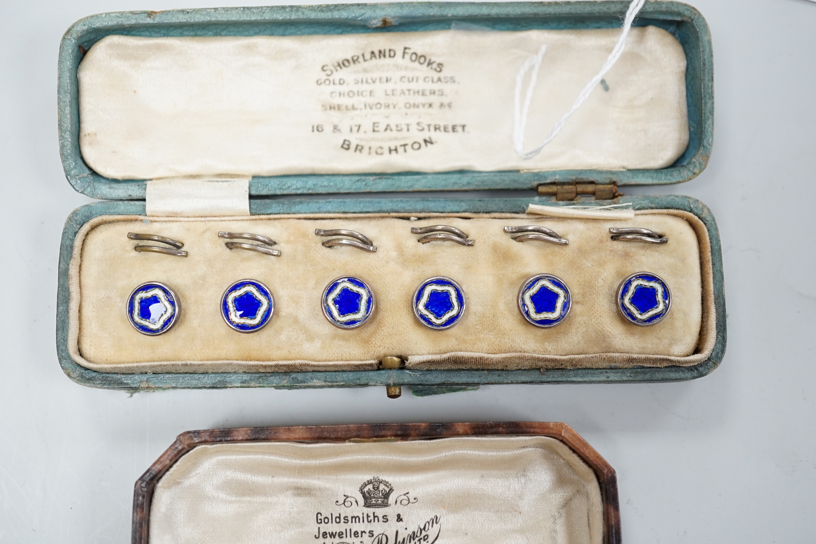 A cased set of six white metal and enamel dress studs and four other dress studs.